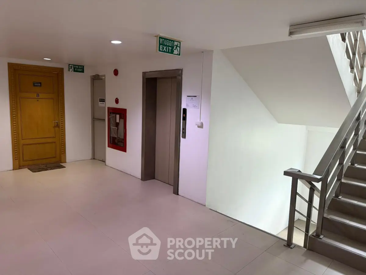 Modern apartment building corridor with elevator and staircase access.