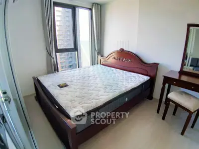 Spacious bedroom with large window and elegant wooden furniture in modern apartment.