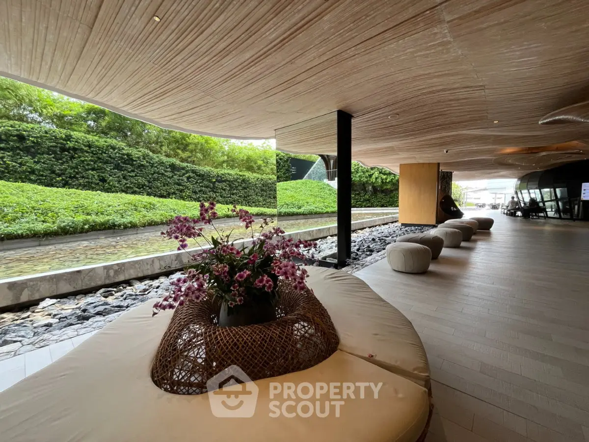Luxurious modern building entrance with elegant seating and lush greenery