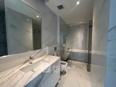 Luxurious modern bathroom with marble finishes and glass shower enclosure