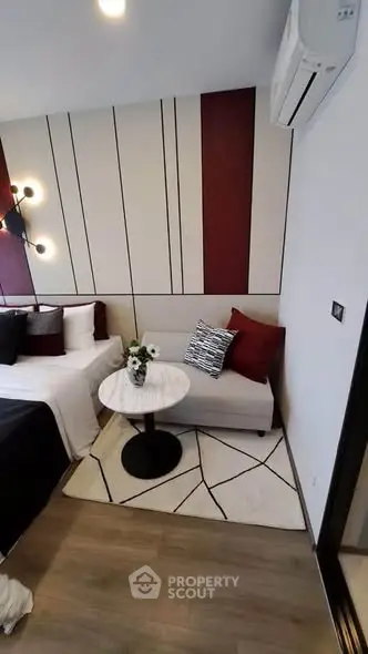 Modern bedroom with stylish decor and cozy seating area, featuring elegant lighting and contemporary design.