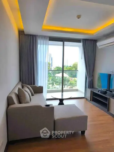Modern living room with stylish sofa and balcony view in a contemporary apartment.
