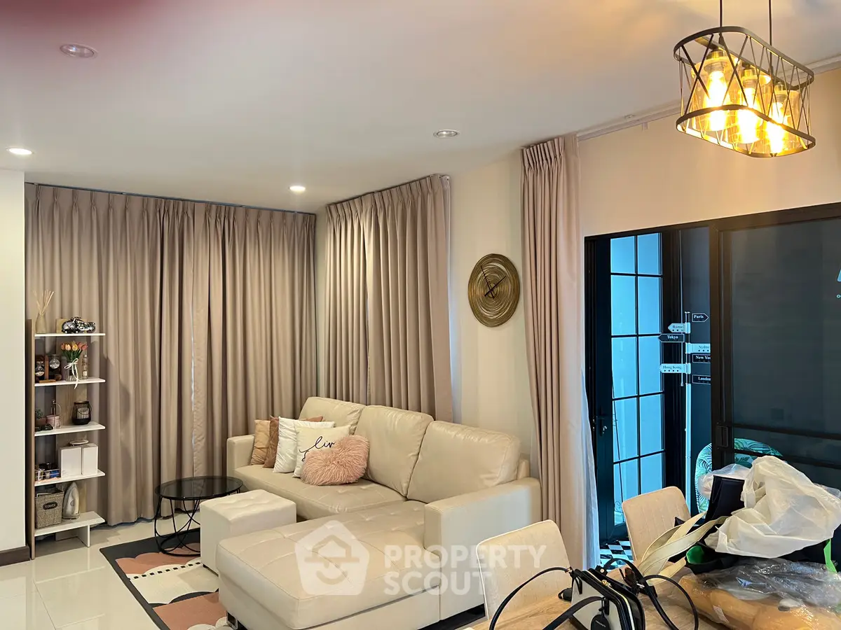 Cozy living room with elegant lighting and modern decor, featuring a plush white sofa and stylish shelving.