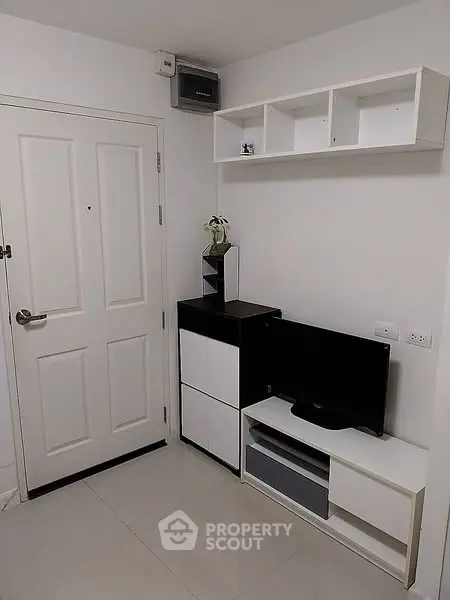 Modern minimalist living room with sleek white furniture and mounted TV unit.