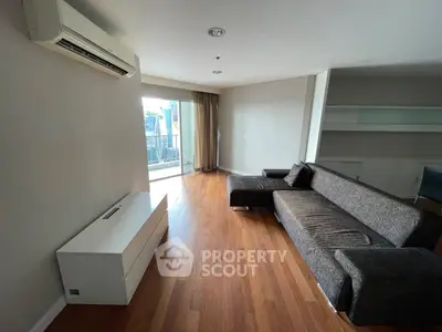 Spacious living room with modern sofa and balcony view in urban apartment