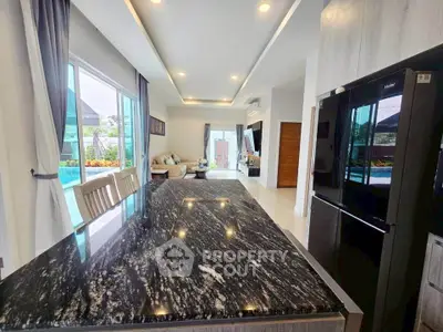 Luxurious open-layout kitchen with pool view and modern appliances