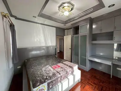 Spacious bedroom with elegant ceiling light and built-in storage
