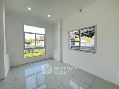 Bright and spacious room with large windows and tiled flooring, perfect for modern living.
