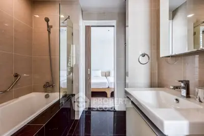 Modern bathroom with sleek fixtures and a glimpse of a cozy bedroom