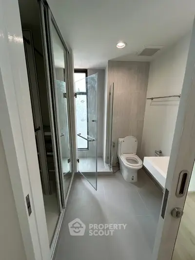 Modern bathroom with glass shower and sleek fixtures in contemporary apartment