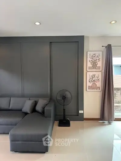 Modern living room with stylish gray sofa and elegant wall decor