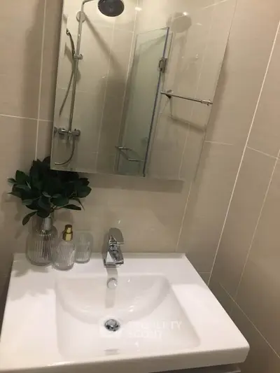 Modern bathroom with sleek sink and stylish shower in contemporary apartment.