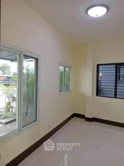 Bright empty room with large windows and tiled floor, perfect for customization.