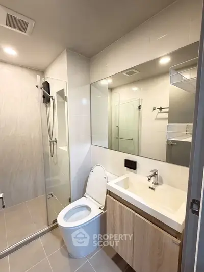 Modern bathroom with sleek design, featuring a glass shower and stylish vanity.