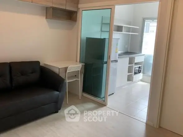 Modern living room with sleek kitchen and glass partition