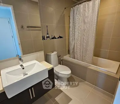 Modern bathroom with sleek fixtures and elegant tile design, featuring a bathtub and stylish vanity.