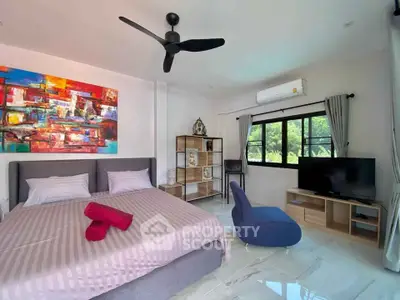 Spacious bedroom with modern amenities, polished tile flooring, vibrant artwork, and ample natural light, perfect for relaxation and comfort.