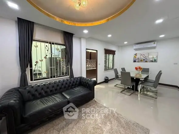 Spacious modern living room with elegant dining area and luxurious leather sofa.