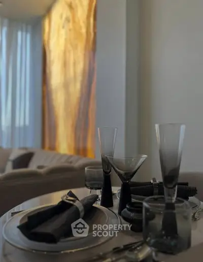 Elegant dining setup with stylish glassware and napkins in a modern living room setting.