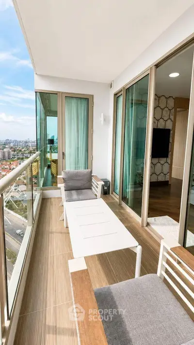 Spacious balcony with modern furniture and city view, perfect for relaxation and entertainment.