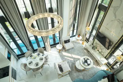 Luxurious double-height living room with elegant chandelier and pool view