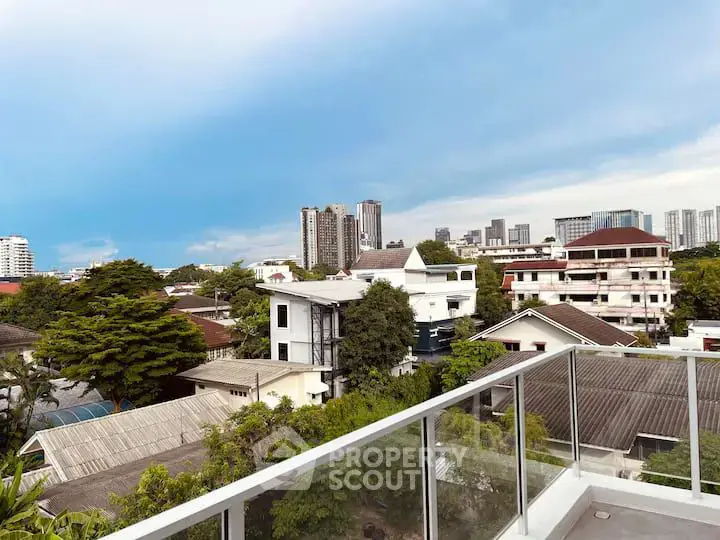 Stunning cityscape view from a modern balcony, showcasing urban living with lush greenery and skyline.