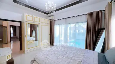 Luxurious bedroom with elegant chandelier and pool view, featuring large windows and stylish decor.