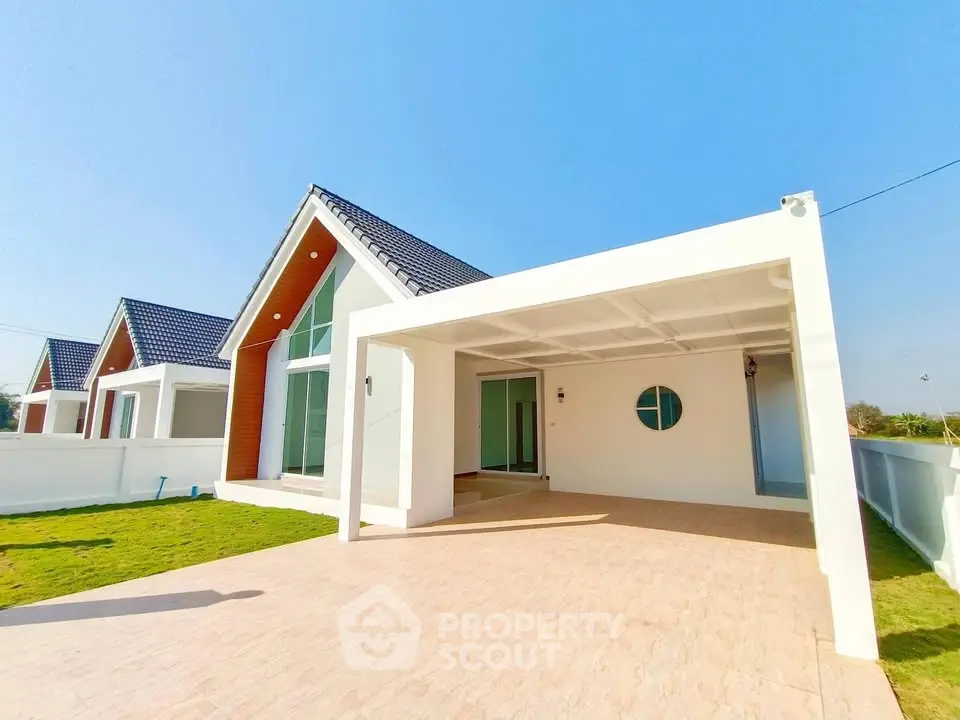 Modern single-story house with spacious driveway and contemporary design.