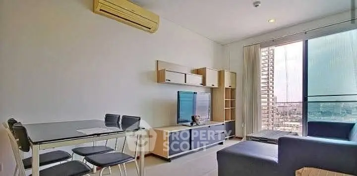 Modern living room with sleek furniture and city view balcony in high-rise apartment.