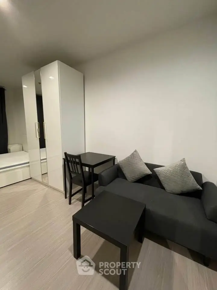 Modern living room with sleek furniture and minimalist design, featuring a cozy sofa and stylish table set.