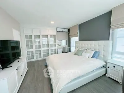 Spacious bedroom with modern decor and ample natural light