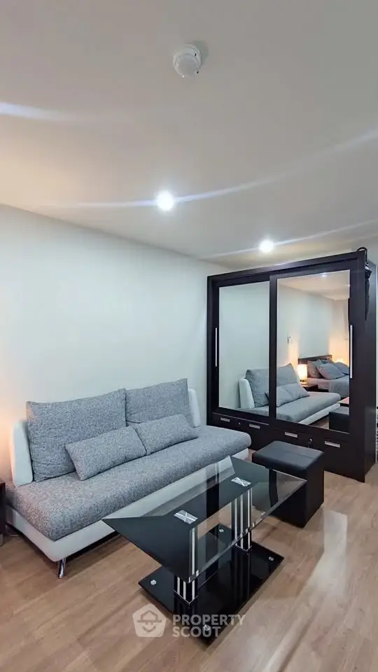 Modern living room with sleek furniture and mirrored wardrobe