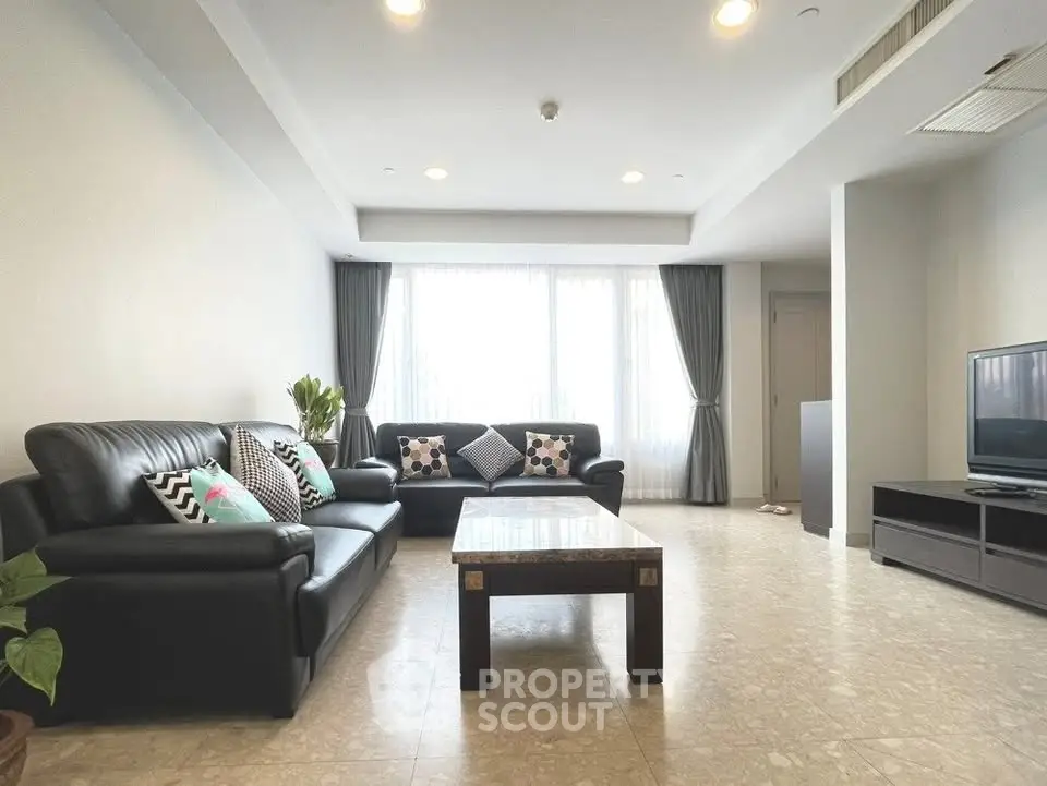 Spacious modern living room with elegant furniture and large windows for natural light.