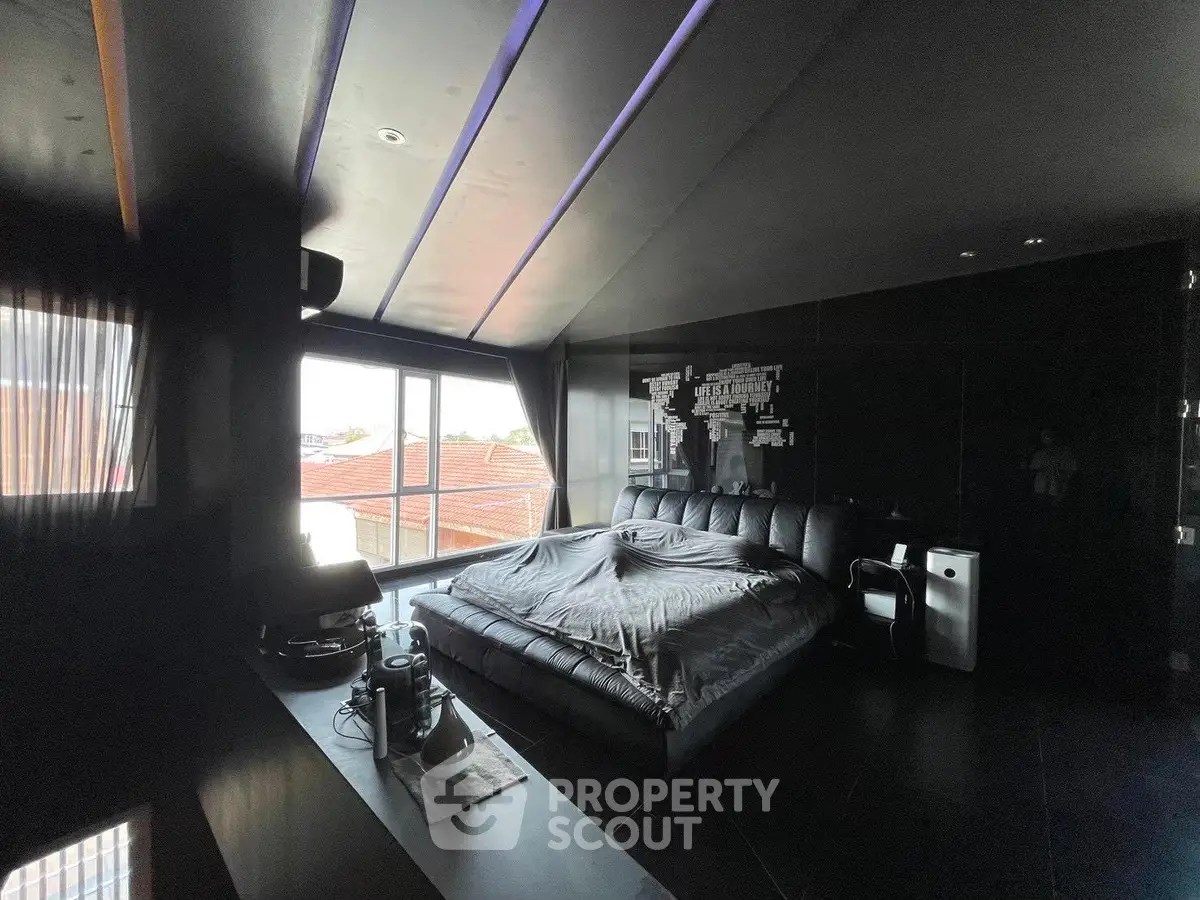 Luxurious dark-themed bedroom with large windows and modern decor