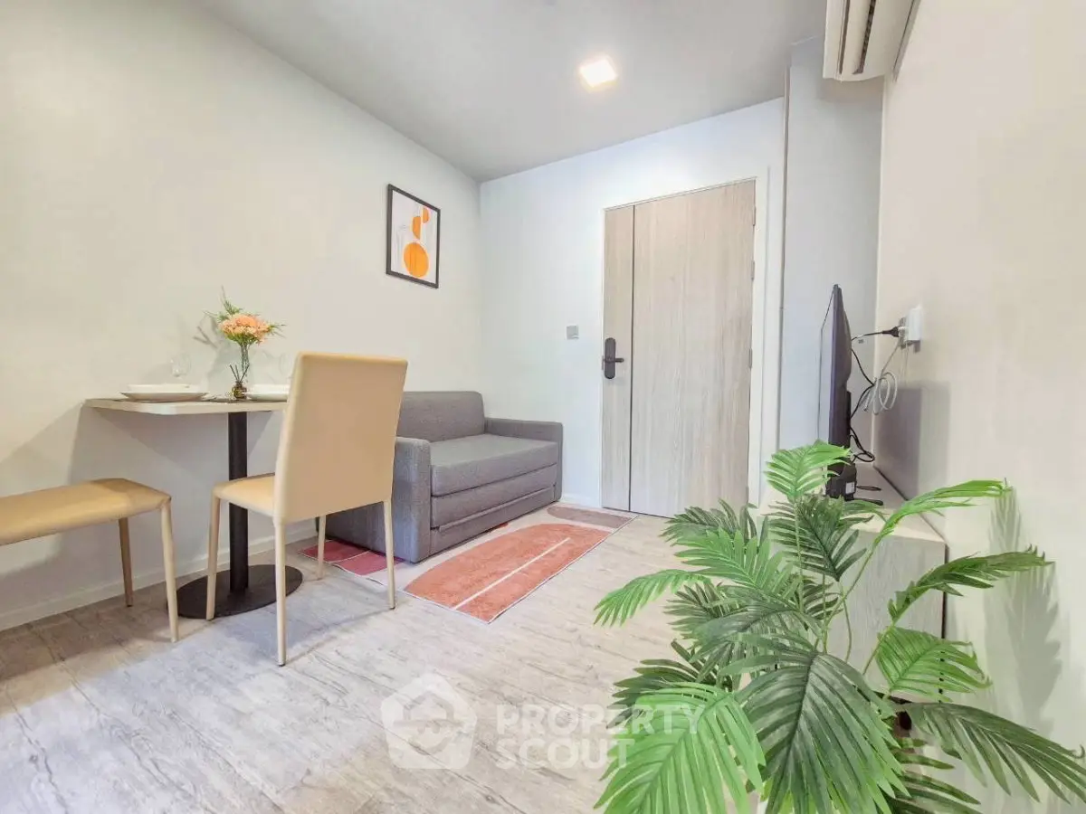 Modern living room with cozy seating and stylish decor in a compact apartment.