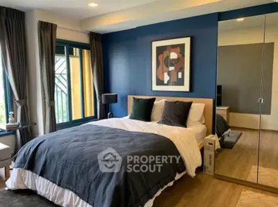 Modern bedroom with stylish decor and large mirror reflecting natural light.