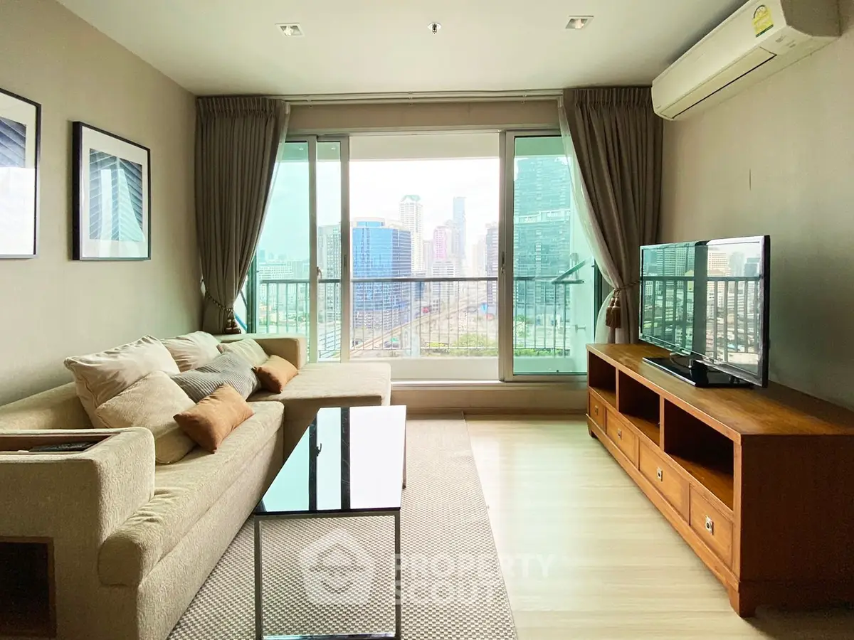 Spacious living room with city view, modern furniture, and large windows in a high-rise apartment.