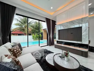 Luxurious living room with pool view, elegant decor, and spacious seating area.