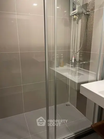 Modern bathroom with glass shower enclosure and sleek fixtures
