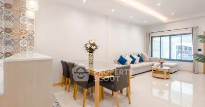 Modern living room with stylish decor and open layout, featuring a cozy dining area and elegant lighting.