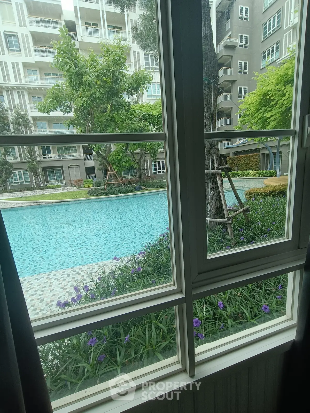 Stunning pool view from window in modern apartment complex