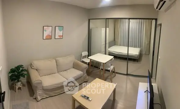 Modern studio apartment with cozy living area and glass partitioned bedroom.