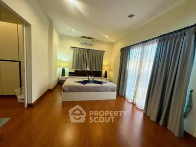 Spacious bedroom with elegant decor and large windows for natural light
