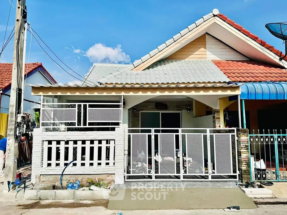 Charming single-story house with tiled roof and fenced front yard in a suburban neighborhood.