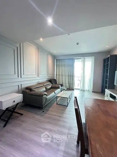 Spacious modern living room with elegant decor and balcony access.