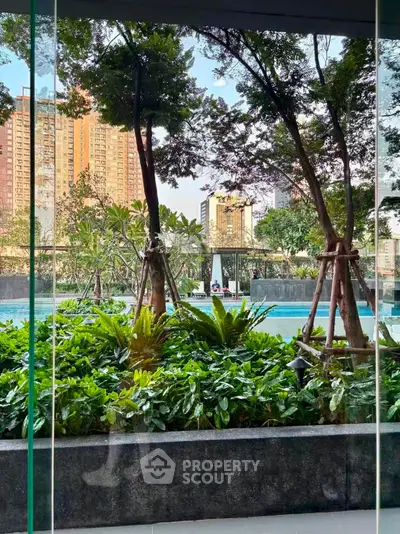 Luxurious urban poolside view with lush greenery and cityscape backdrop, perfect for relaxation and leisure.