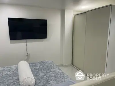 Modern bedroom with wall-mounted TV and sliding wardrobe