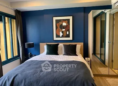 Modern bedroom with stylish decor and large windows in a contemporary apartment.