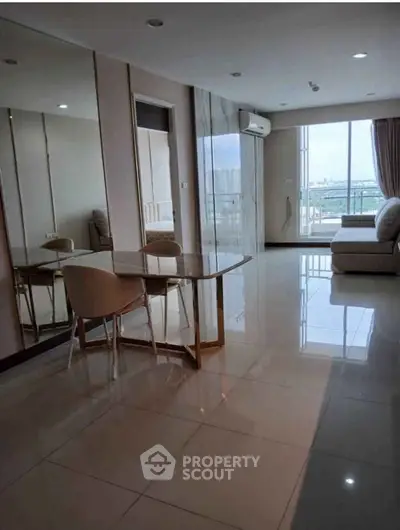 Spacious modern living room with large windows and elegant furniture, offering a bright and inviting atmosphere.