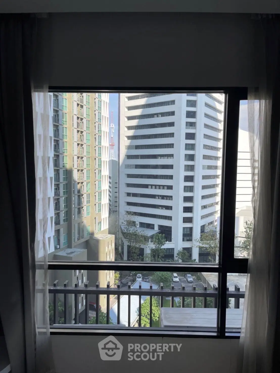 Stunning urban view from a high-rise apartment window showcasing modern cityscape.